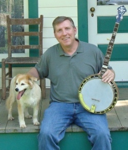 Alan Tompkins on the porch at Bill Monroe's home place with the dog from the Cumberland Highlanders show on RFD-TV